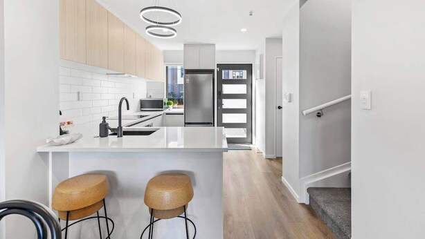 A modern kitchen with a central island, stainless steel appliances, and a minimalist design.