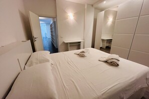 Una camera d'albergo con un letto, una scrivania e uno specchio.