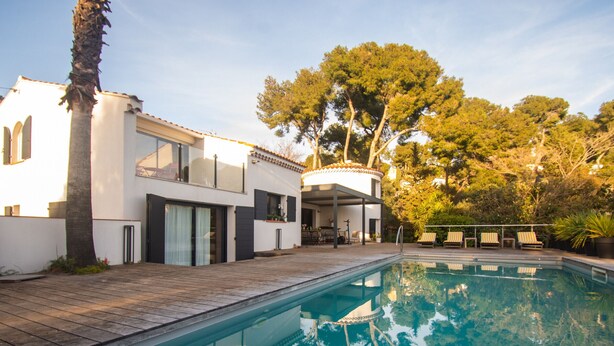 A modern house with a swimming pool, a covered patio, and a view of trees. - Carqueiranne: Charming Villa with Pool, Sea View, for 8 Guests (Carqueiranne)