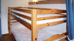 A bunk bed with a wooden frame and white bedding. - Spacious studio 6 ppl, ski-in/ski-out, Free Wifi (Les Orres)