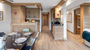 Una cocina moderna con armarios de madera y un comedor con mesa dispuesta para cuatro.