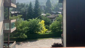 Un quartier résidentiel avec un parking, des immeubles et une montagne en arrière-plan.