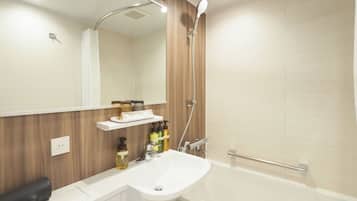 A modern bathroom with a white sink, a mirror, a shower, and a wooden vanity.
