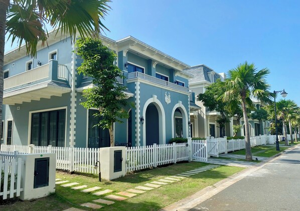 A two-story building with a white picket fence, large windows, and a balcony. - Wonderland Royal Mansions Ho Tram (Ho Chi Minh Municipality)