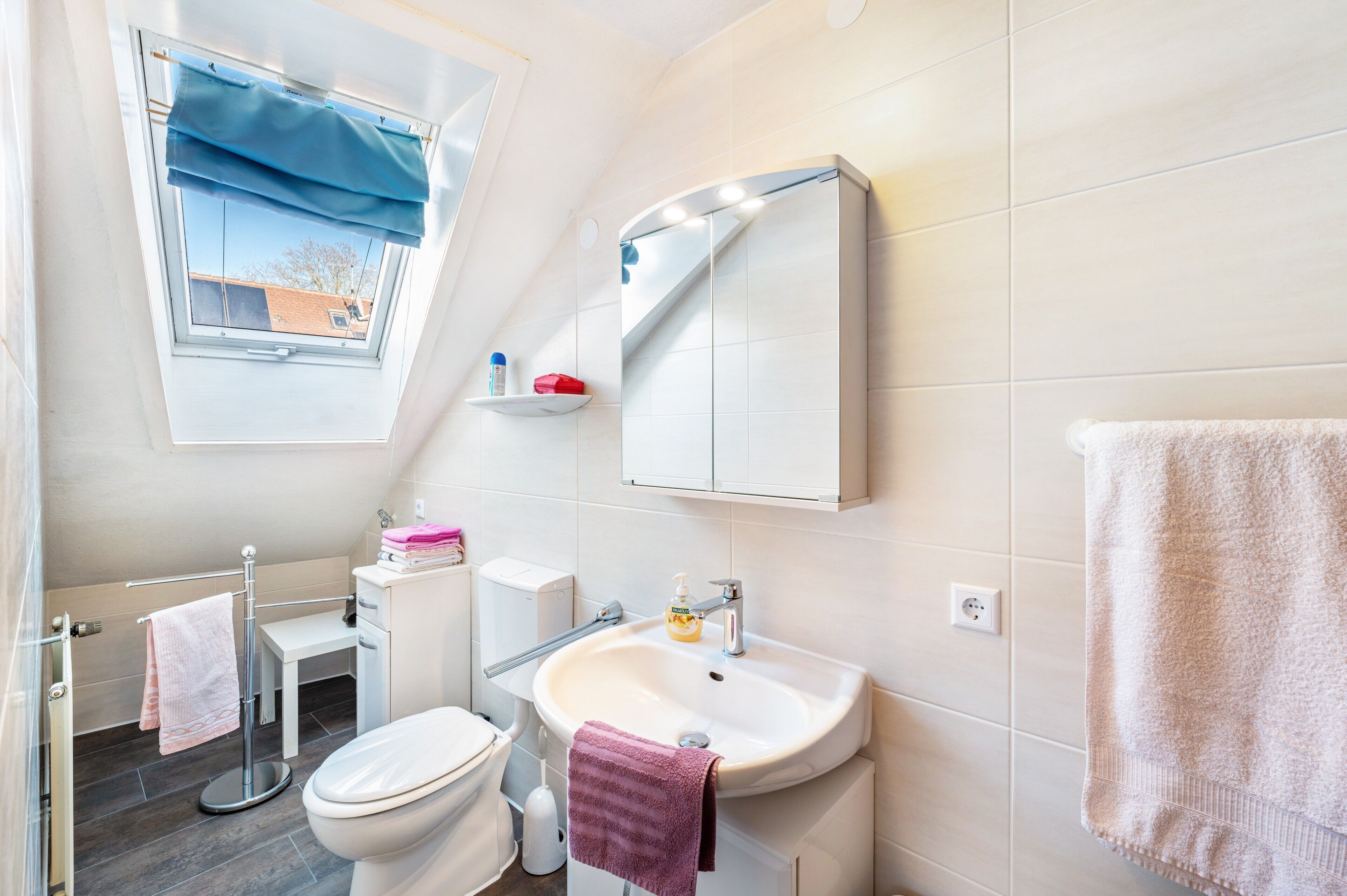 Une petite salle de bain comprenant des toilettes, un lavabo et une fenêtre.