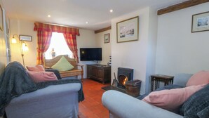 A cozy living room with a fireplace, a television, and comfortable seating.