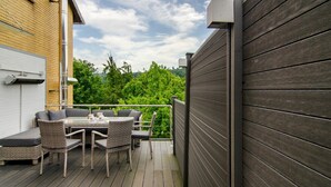 A deck with outdoor furniture, a white garage door, and a wooden fence.