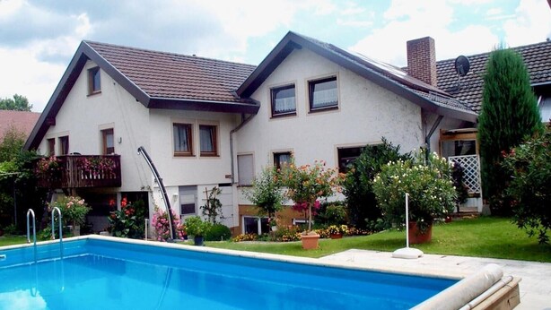 A two-story house with a swimming pool in the foreground. - Apartment 'Linde' with Shared Garden, Balcony and Wi-Fi (Endingen am Kaiserstuhl)