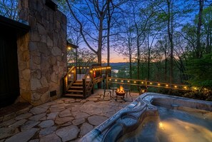 A stone building with a hot tub, outdoor seating, and a fire pit. - Lake Burton cottage with hot tub, lake views, and 3 bedrooms. (Clarkesville)
