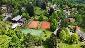 Vista aérea de una zona residencial con canchas de tenis, un club de campo y casas circundantes.