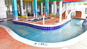 An indoor swimming pool with a colorful ceiling and a white staircase leading to a higher level.
