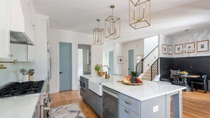 A modern kitchen with a central island, built-in appliances, and pendant lighting.