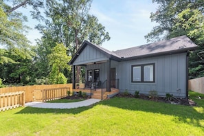 A single-story house with a covered porch, a front door, and a small front yard.