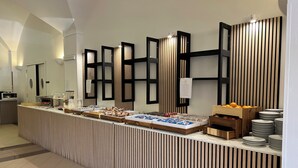 Ein reichhaltiges Buffet mit verschiedenen Speisen und einer Wandverkleidung aus Holz.