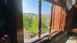 Una finestra in legno con vista su una città e del verde.