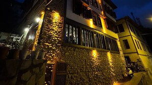 Un edificio a due piani con pareti in pietra e un balcone.