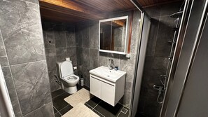 A modern bathroom with a toilet, sink, and shower.