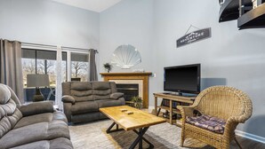 A living room with a sofa, armchair, and a wooden coffee table. - Fairway Haven For 9! (Branson)
