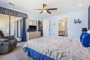 A bedroom with a bed, a desk, a chair, a television, and a ceiling fan. - Fairway Haven For 9! (Branson)