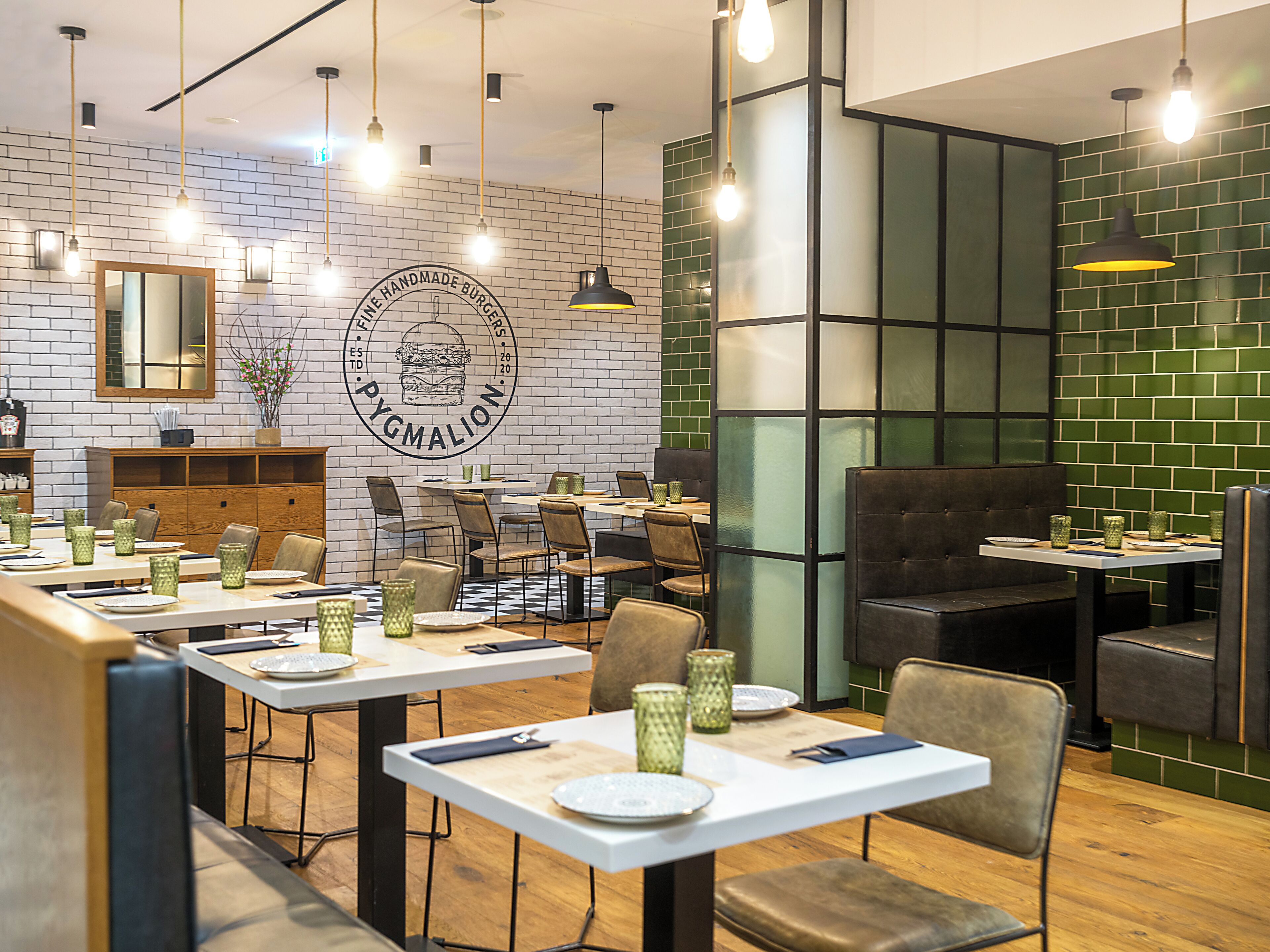 Interior de restaurante con paredes de ladrillo, mesas y sillas de madera.