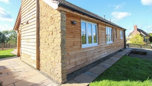 A wooden house with a stone foundation, large windows, and a tiled roof. - Dingle (Kidderminster)