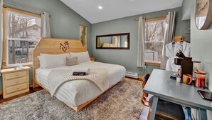A bedroom with a bed, bedside tables, a desk with a coffee machine, and a mirror. - King Size - Romantic - Massage - Pet Friendly (Blakeslee)
