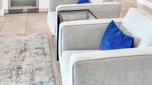 A modern living room with a grey sofa set, a small coffee table, and a patterned rug.