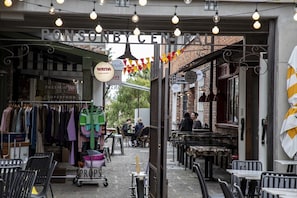 An outdoor market area with clothing stalls, a sign for Watda, and a sign for Ponsby Central.