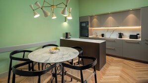 A modern kitchen with a marble island, black chairs, and a unique light fixture. - ENCHANTING PENTHOUSE 360° Panoramic View in the Heart of Florence. (Firenze)