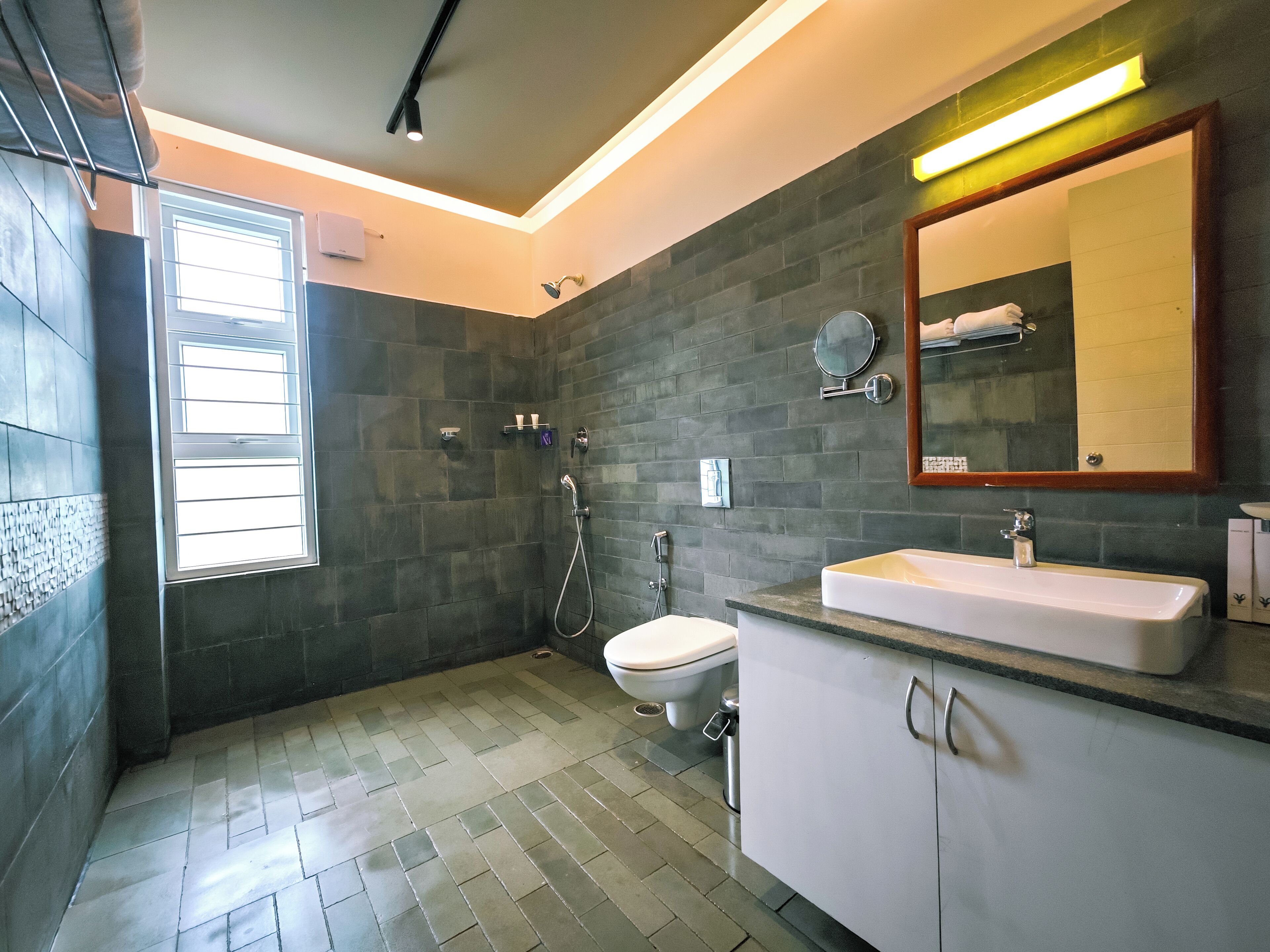 A modern bathroom with a shower, toilet, and sink.