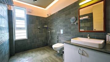 A modern bathroom with a shower, toilet, and sink.