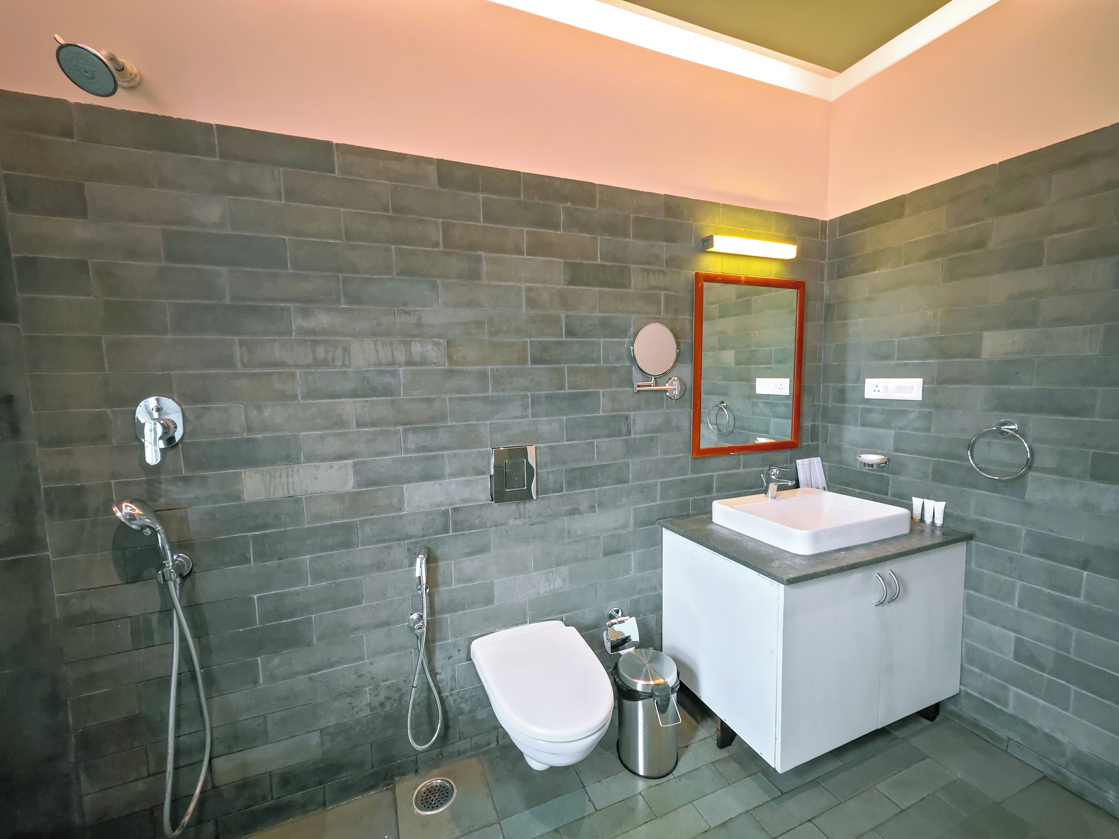 A modern bathroom with a white sink, a toilet, and a shower area.