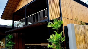 A modern two-story building with a wooden facade and a balcony. - Mayfair Garden Resort (Panglao)