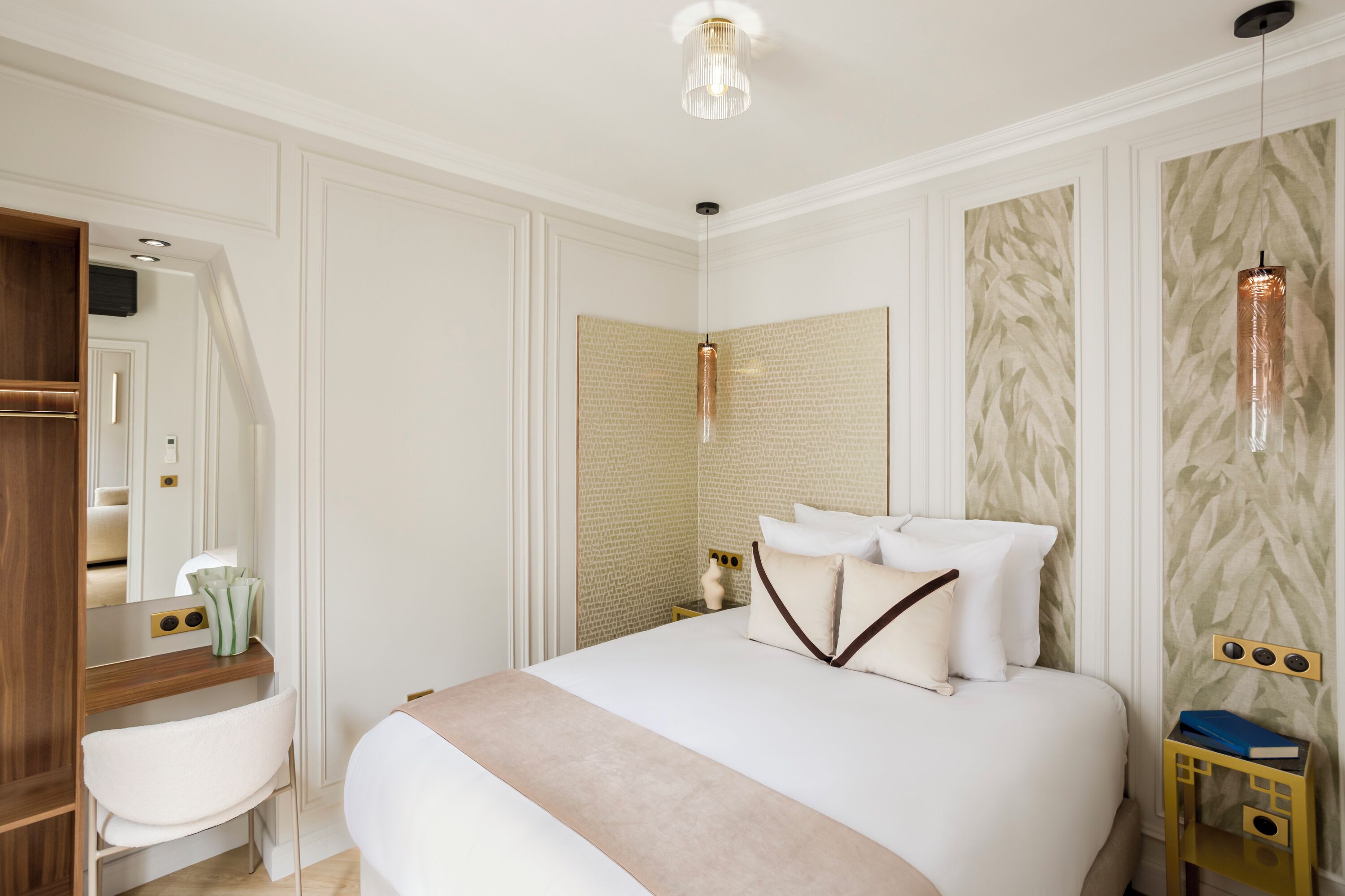 A neatly arranged bedroom with a bed, bedside table, and a mirror.