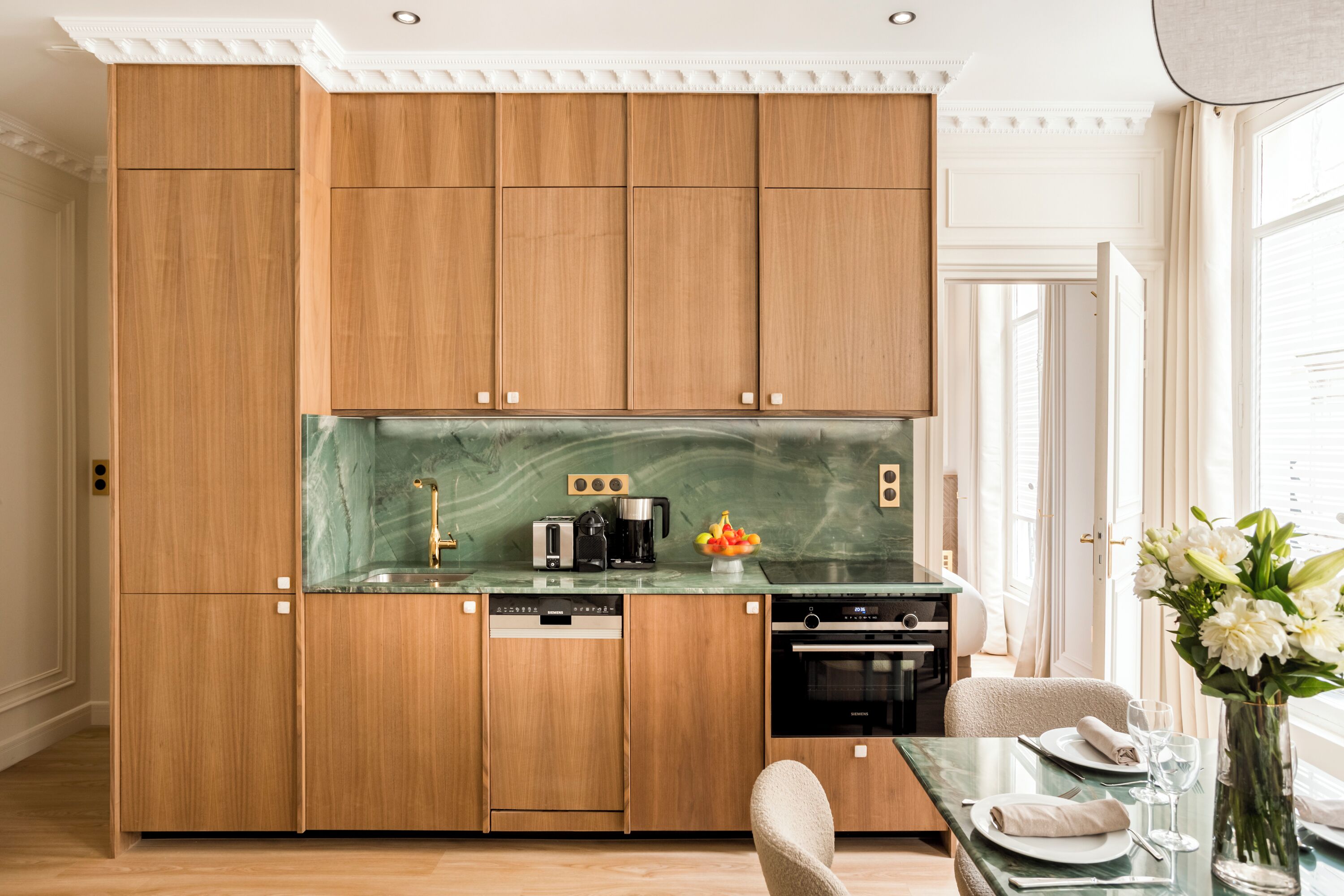 A compact kitchen with wooden cabinets, a marble countertop, and modern appliances.