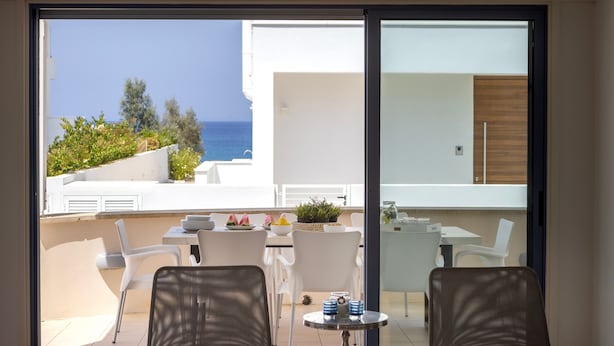 A balcony with a view of the sea, white furniture, and a small table with a plant. - Protaras Seaside Villa Protamare 32 (Paralimni)