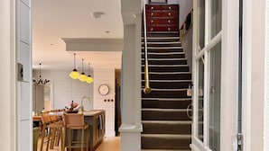 A staircase with a patterned carpet leading to a landing with a framed picture. - The Lodge @Sunnybank House - unique country lodge overlooking Clifden Town (Clifden)
