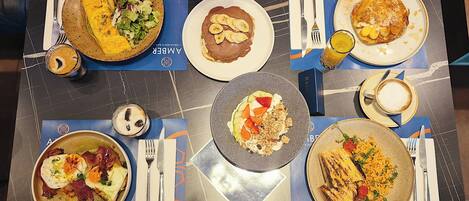 A breakfast buffet with various dishes including pancakes, eggs, and fruits.