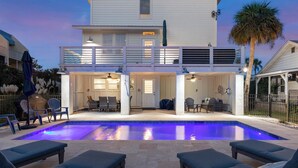 Une maison à deux étages dotée d’une piscine, d’un espace extérieur aménagé et d’un patio couvert.