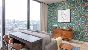 Ein modernes Wohnzimmer mit großem Fenster, Wand mit Muster und Blick auf die Stadt.