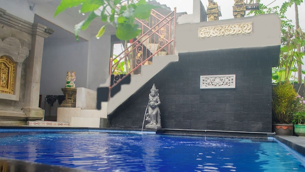 A swimming pool with a statue, a staircase, and architectural details. - Kabera Bungalow Ubud (Ubud)