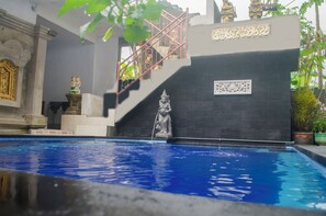 A swimming pool with a statue, a staircase, and architectural details. - Kabera Bungalow Ubud (Ubud)
