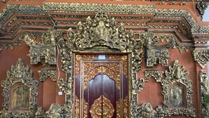 A richly decorated door with intricate carvings and a central emblem. - Kabera Bungalow Ubud (Ubud)