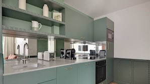 Une cuisine dotée de meubles de couleur turquoise, d’un évier en acier inoxydable et d’appareils électroménagers modernes.