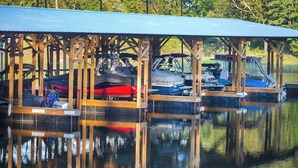 A covered boat dock with several boats moored underneath.