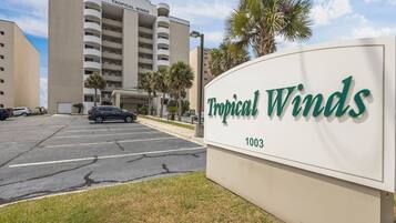 Schild für das Hotel Tropical Winds mit Parkplatz davor.
