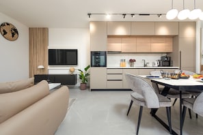 A modern kitchen with a dining area, a flat-screen TV, and a potted plant. - Villa Evita Zadarvillas (Škabrnja)