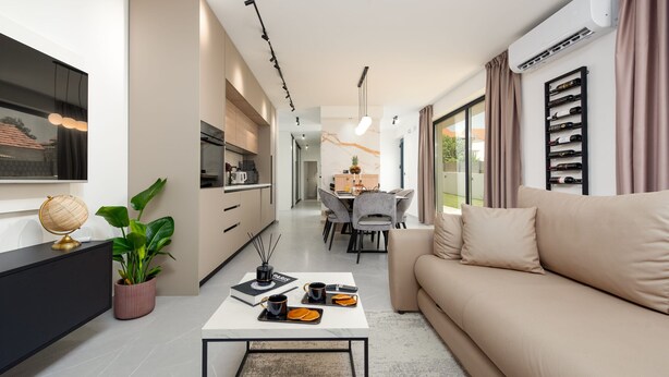 A modern living room with a sofa, coffee table, and a dining area with chairs and a table. - Villa Evita Zadarvillas (Škabrnja)