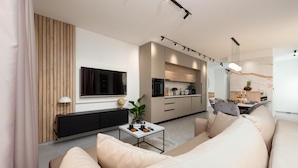 A modern living room with a sofa, a coffee table, and a TV. There is a kitchen area with cabinets and a dining table. - Villa Evita Zadarvillas (Škabrnja)