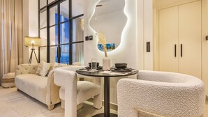 Un salon moderne avec une table ronde, un canapé et une grande fenêtre.